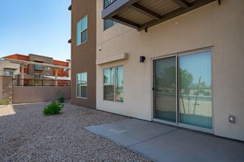 A modern house with a gravel driveway and a clear blue sky.